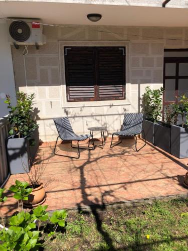 two chairs sitting on a patio in front of a house at M&M apartments in Tivat