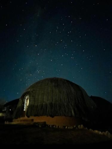 a domed building under a night sky with stars at Swazi Dreams. (Nqabaneni Eco-Volunteering.) in Usutu