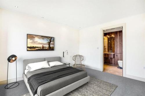a white bedroom with a bed and a bathroom at Elegant & Luxury 2BD Penthouse in London Fulham in London