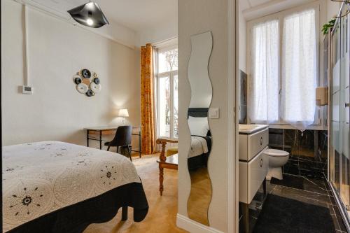 - une chambre avec un lit et une salle de bains pourvue d'un lavabo dans l'établissement Hôtel Henri IV, à Tarbes