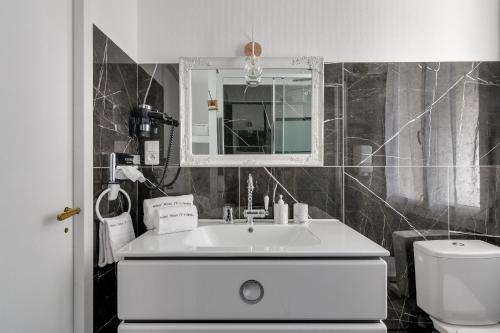 a bathroom with a white sink and a toilet at Hôtel Henri IV in Tarbes