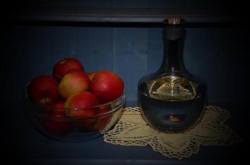 a bowl of apples and a bottle on a table at Haus Bergfrieden in Lermoos
