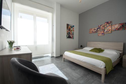 um quarto com uma cama, uma cadeira e uma janela em Casa Vacanze Family House posizione centralissima em Civitavecchia