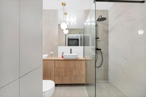 a bathroom with a sink and a shower at Lumina 2-room apartment with beautiful view Lodz in Łódź