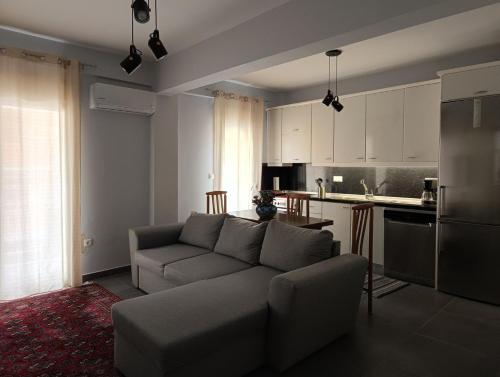 a living room with a couch and a kitchen at NP apartment in Neoi Epivates