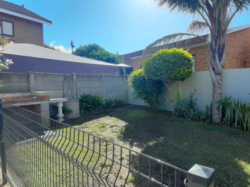 a fence in front of a yard with a tree at 22 on Port Natal Hartenbos in Hartenbos