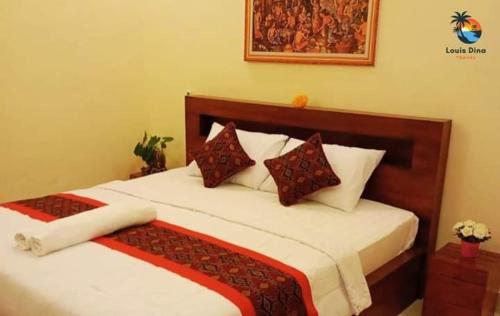 - une chambre dotée d'un grand lit avec des draps et des oreillers blancs dans l'établissement Dana guest house, à Ubud