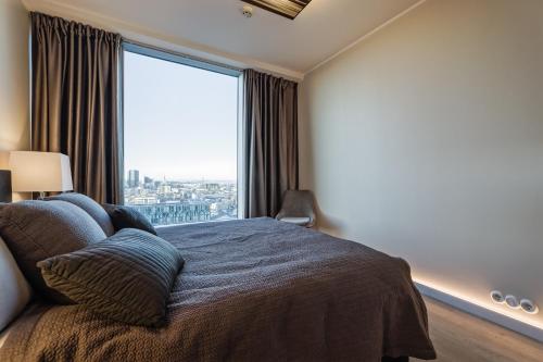 a bedroom with a bed and a large window at Fahle building, skyline view 1 bedroom Flat near Centre in Tallinn
