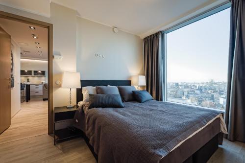 a bedroom with a large bed with a large window at Luxurious, Skyline View Apartment near Centre in Tallinn