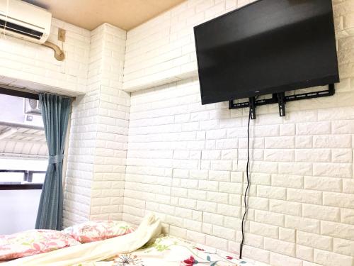 una TV a schermo piatto appesa a un muro di mattoni di 4 minute walk to station. Direct to Shibuya and Shinjuku in 35minutes a Nishi-tsuruma