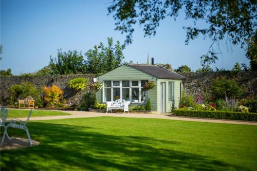 a green greenhouse in a garden with a lawn at County Arms Birr in Birr