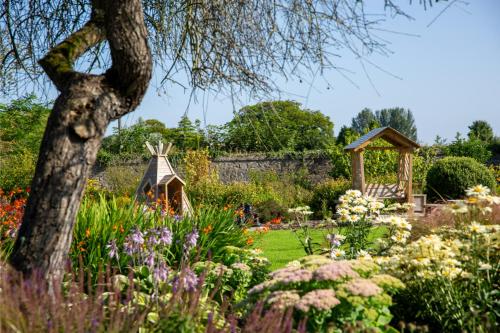 a garden with flowers and a gazebo at County Arms Birr in Birr