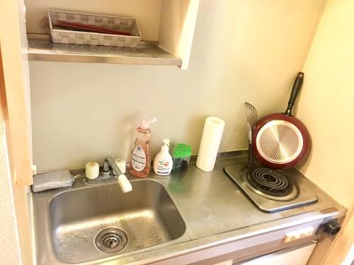 a kitchen counter with a sink and a microwave at 4 minute walk to station. Direct to Shibuya and Shinjuku in 35minutes in Nishi-tsuruma