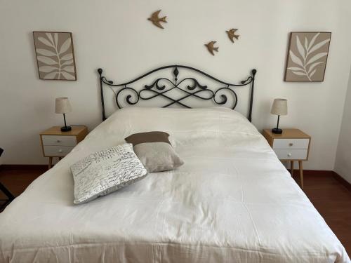 ein Schlafzimmer mit einem weißen Bett und zwei Nachttischen in der Unterkunft Appartamento Pianzola in Orvieto