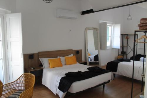 コスタ・ダ・カパリカにあるReal Guest Houseのベッドルーム1室(ベッド2台、鏡付)