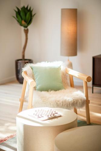 a chair with a pillow and a table in a room at Villa Marie et Martin in Dijon