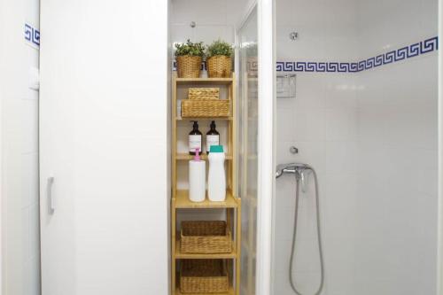a bathroom with a shelf with bottles and baskets at Bambu Beach Studio by BHomesCostaBrava in Platja d'Aro