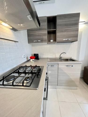 a kitchen with a stove and a sink at La Casetta tra Alghero e Stintino in Palmadula