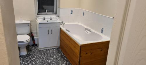 een badkamer met een bad, een toilet en een wastafel bij Super Comfy & Family Friendly Home in Leigh