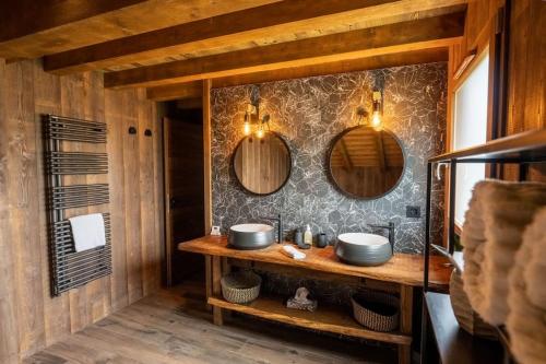 a bathroom with two sinks and two mirrors at Chalet de standing, Jacuzzi, Sauna, Perle Noire in Gérardmer