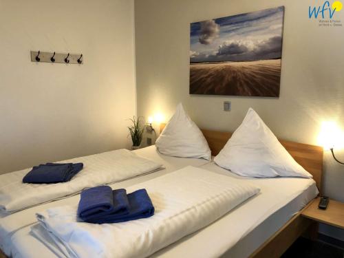 a bedroom with two beds with towels on them at Villa Vivaldi Ferienwohnung 2 in Wangerooge