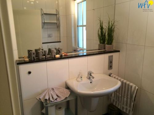 a bathroom with a sink and a mirror at Villa Vivaldi Ferienwohnung 2 in Wangerooge