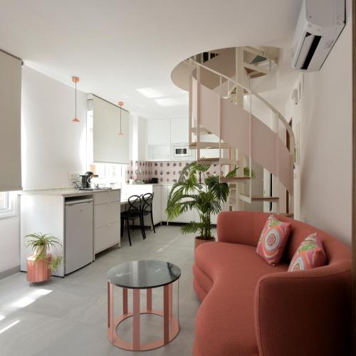sala de estar con sofá rojo y mesa en PATIO de SOMBRA · Urban Suites, en Granada