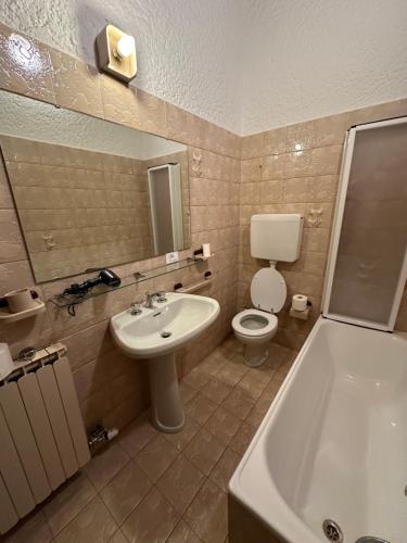 y baño con lavabo, aseo y bañera. en Val di Sole Apartment, en Monclassico