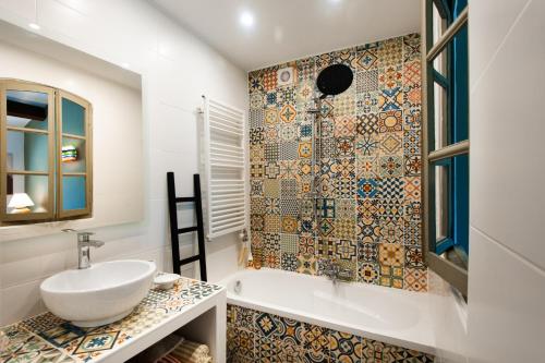 une salle de bain avec une baignoire, un lavabo et une douche dans l'établissement Mas Amande - Maisons mitoyennes avec piscine, à Istres