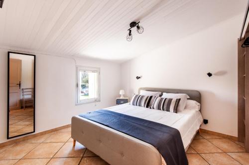 une chambre avec un grand lit dans une pièce dans l'établissement Mas Amande - Maisons mitoyennes avec piscine, à Istres