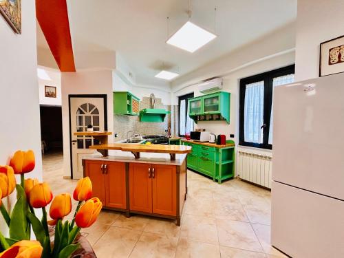 a kitchen with green cabinets and a white refrigerator at Seamply apartment il mare in 1 minuto in Maiori
