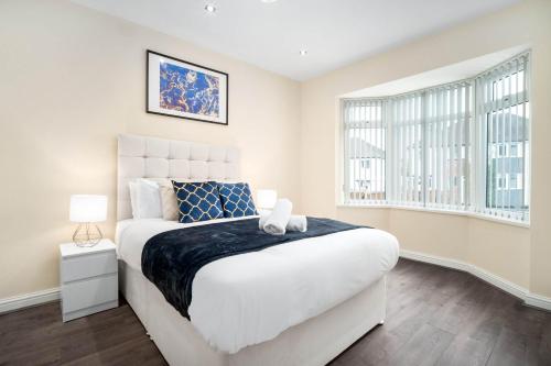 Un dormitorio con una gran cama blanca y una ventana en Luxury 4 Bedroom House - Harborne - Top Rated - Parking - Garden - 6CO en Birmingham