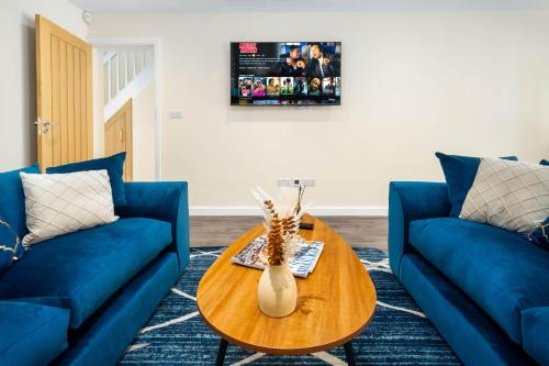 una sala de estar con 2 sofás azules y una mesa. en Luxury 4 Bedroom House - Harborne - Top Rated - Parking - Garden - 6CO en Birmingham