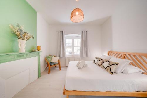 une chambre avec un lit blanc et une fenêtre dans l'établissement Le Verdé - Bel appt en plein cœur de Bordeaux, à Bordeaux
