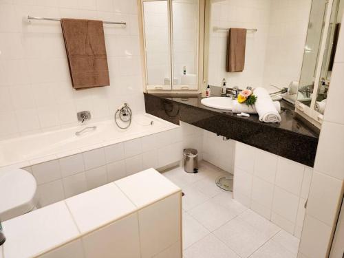 a white bathroom with a sink and a tub and a toilet at Villa G5 - Selborne Golf Estate in Pennington
