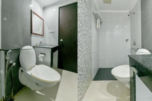 a bathroom with a toilet and a sink and a shower at Centre Point in Cochin