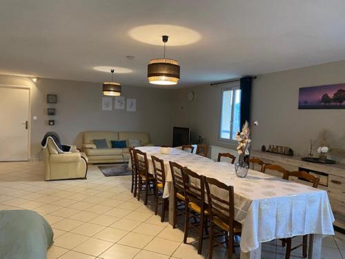- un salon avec une grande table et des chaises dans l'établissement Domaine de la Noiseraie, à Belleville-sur-Saône