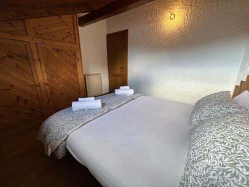 1 dormitorio con cama blanca y armario de madera en Val di Sole Apartment, en Monclassico