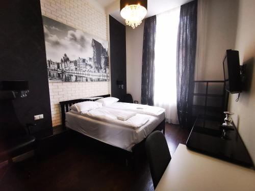 a bedroom with a bed with a picture on the wall at Apartament Piwna IV in Gdańsk