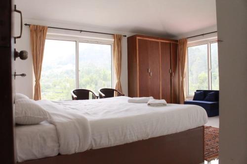1 dormitorio con cama grande y ventana grande en Green Villa Ooty by Lexstays, en Ooty