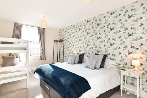 1 dormitorio con 1 cama con pared con estampado de pájaro en Cliff House, en Longstone