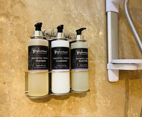 a group of three shampoo bottles on a wall at The Galleries No 2 in Spean Bridge
