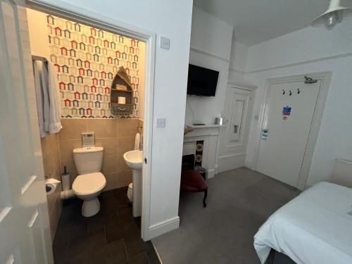 a bathroom with a toilet and a sink at Hotel 50 in Bournemouth