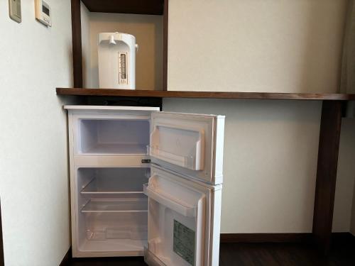an empty refrigerator with its door open in a kitchen at Chateraise Hotel Nagano in Nagano