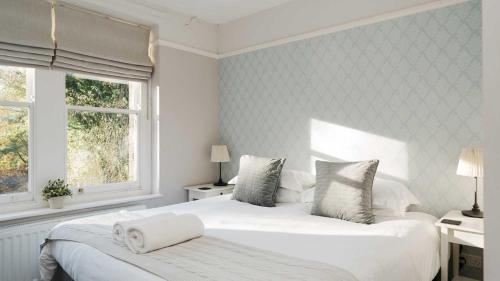 een witte slaapkamer met een groot bed en een raam bij Dale House in Buxton