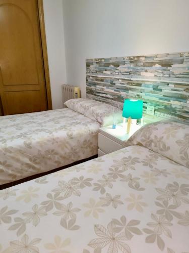a bedroom with two beds and a blue at APARTAMENTOS TURíSTICOS MONTASOL 1 in Montánchez