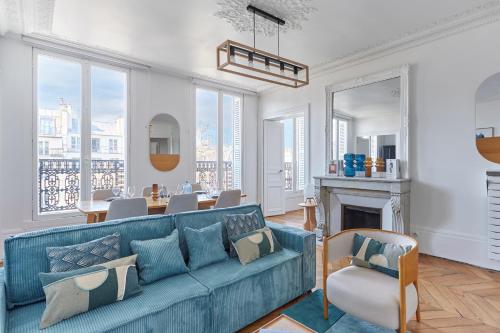 un salon avec un canapé bleu et une table dans l'établissement Residence Le Marais by Studio prestige, à Paris