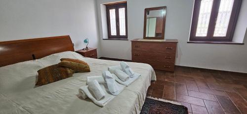 1 dormitorio con 1 cama con toallas en B&B La Fonte, en Staffolo