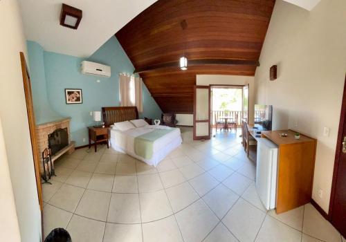 a bedroom with a bed and a living room at Pousada Finlândia in Penedo