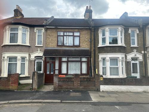 a brick house with a red door on a street at London Holiday Home in London